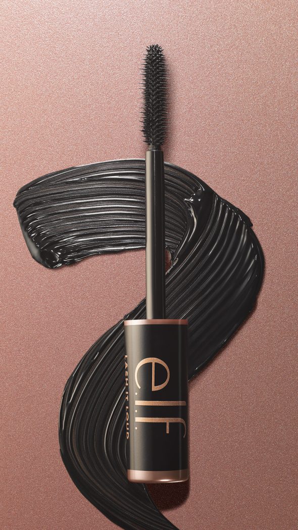 Viser Lash It Loud Mascara børste hode med svart mascara bak smurt utover en gyllen bakgrunn
